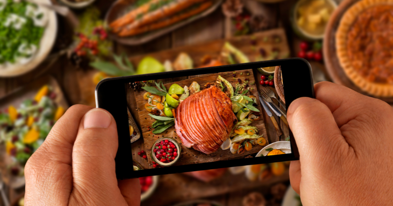 Someone taking a picture of a holiday food spread with phone