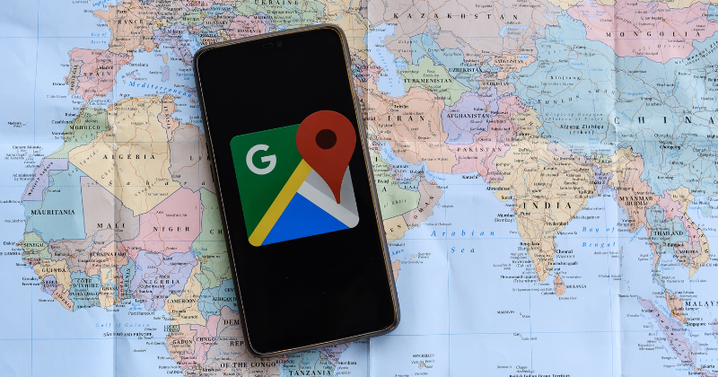 image of phone with google icon sitting on top of a map